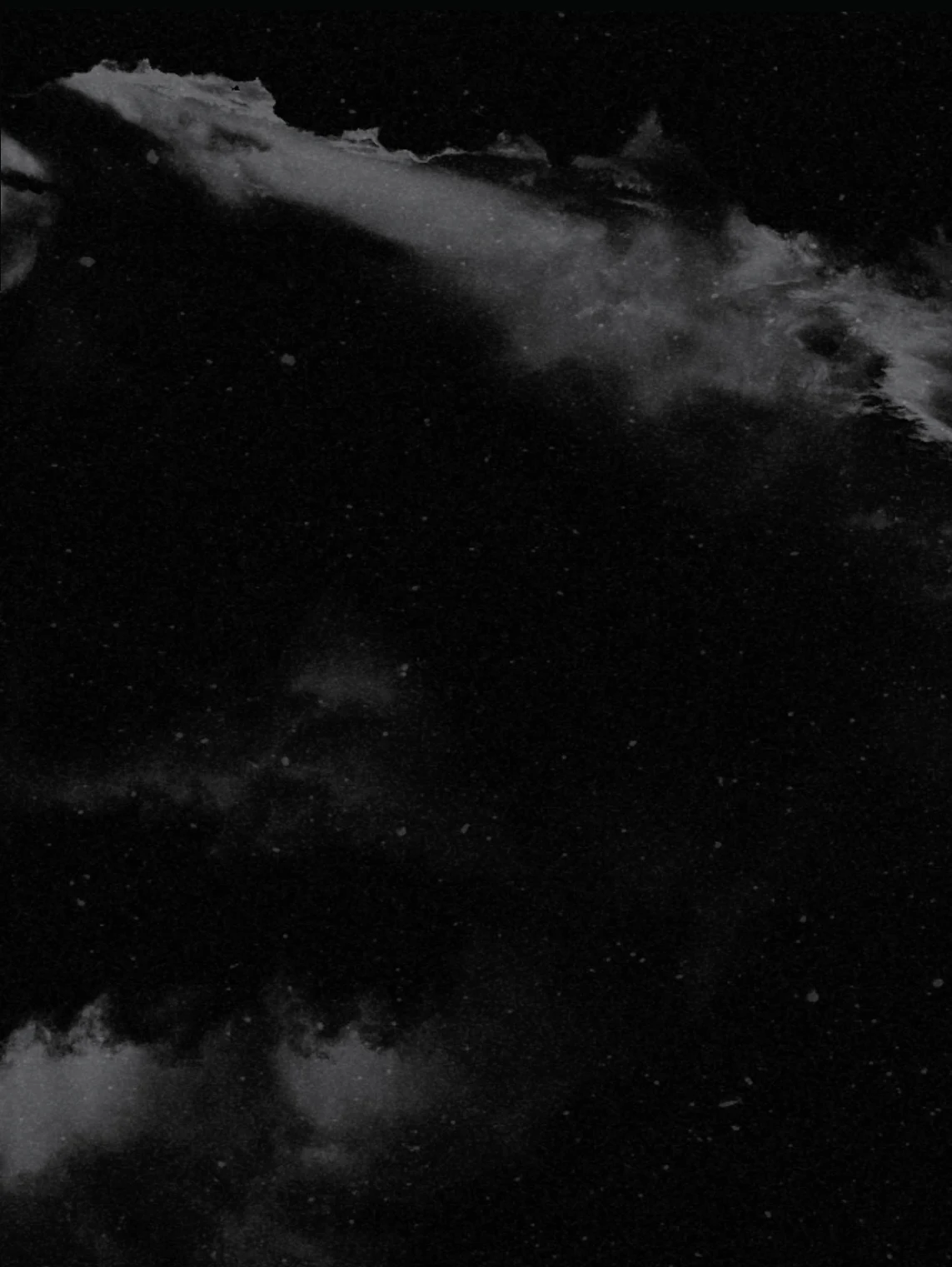 Abstract dark storm clouds streaking across a nearly black sky in muted grey tones